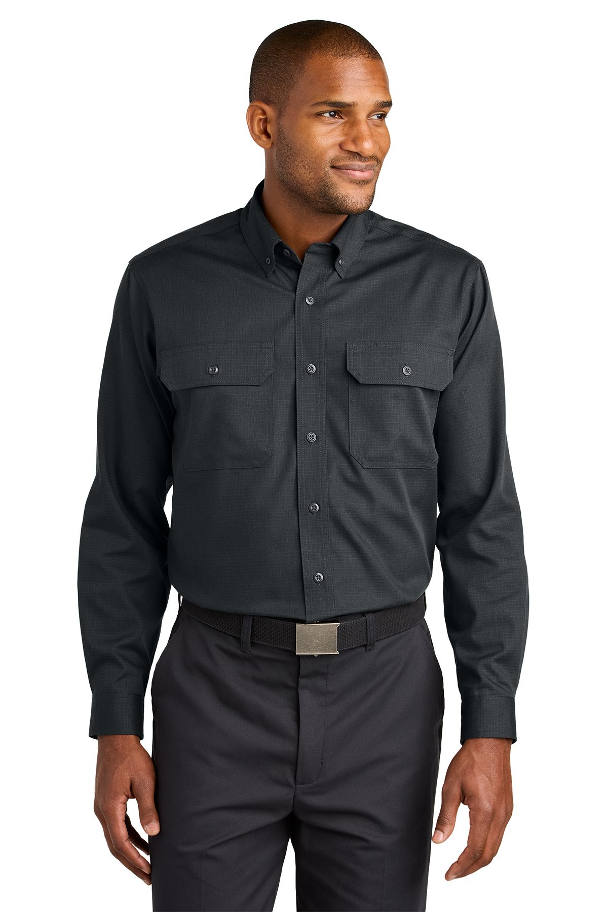 Man in a black long-sleeved shirt and gray pants smiles, standing against a white background.