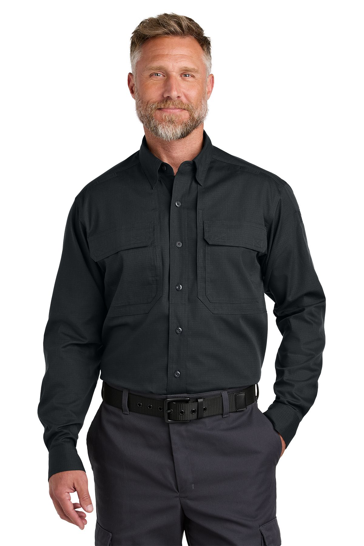 Man in black button-up shirt and gray pants, hands in pockets, standing.