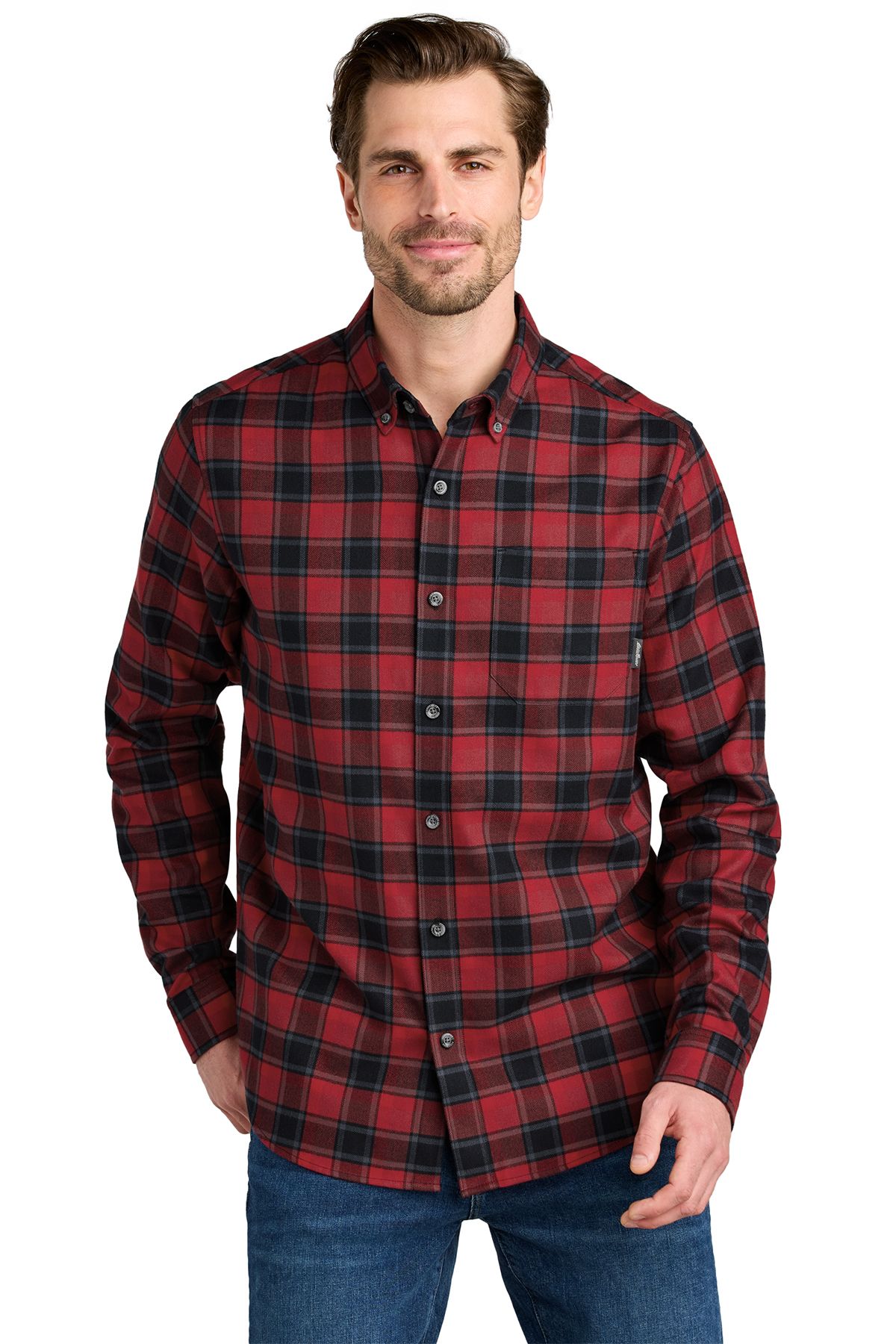 Man in green plaid shirt and blue jeans, looking slightly off-camera.