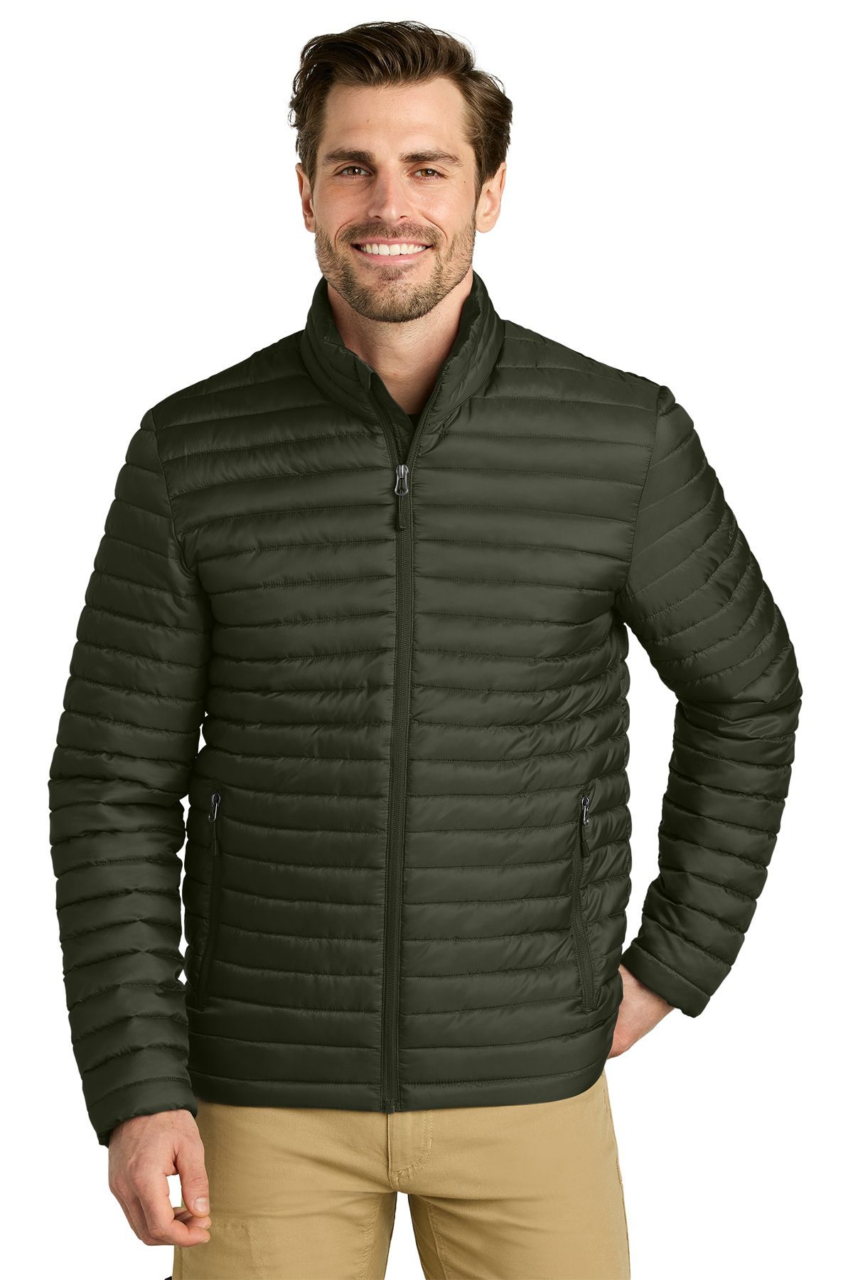 Man wearing a teal puffer jacket, smiling. Stands in front of a white background, wearing khaki pants.