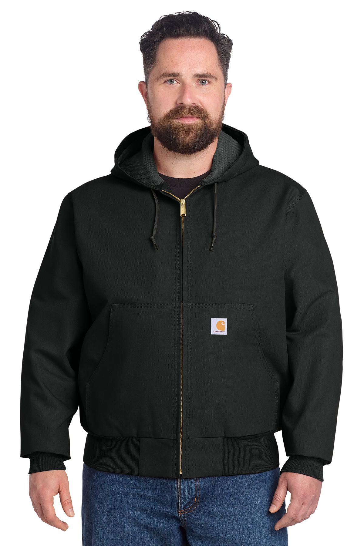 Man wearing a black Carhartt jacket with a hood, standing, smiling.