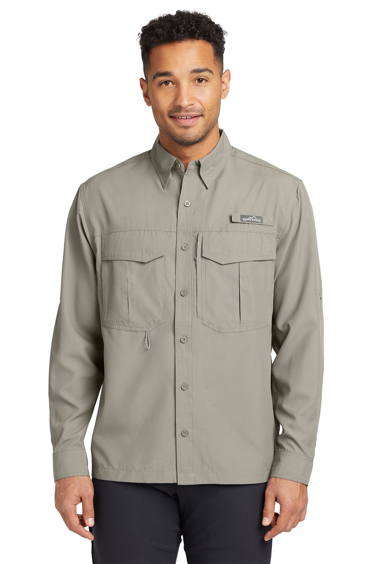 Man wearing a teal button-up shirt with pockets, standing and smiling.