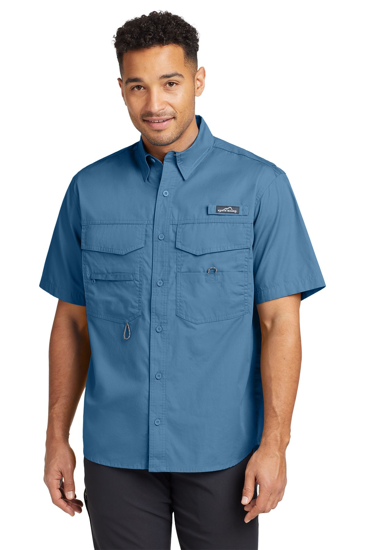 Man wearing a blue short-sleeved fishing shirt, smiling.