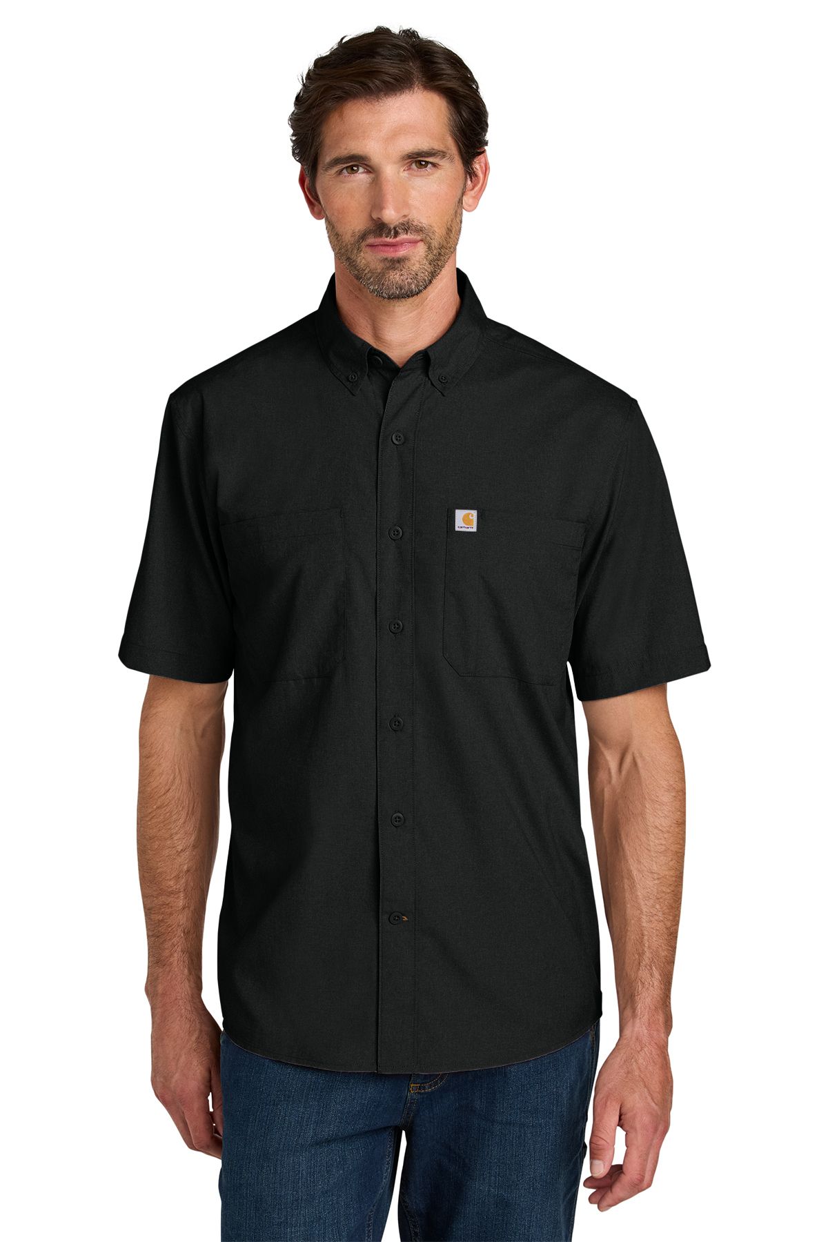 Man in black short-sleeved button-down shirt and blue jeans, standing indoors.