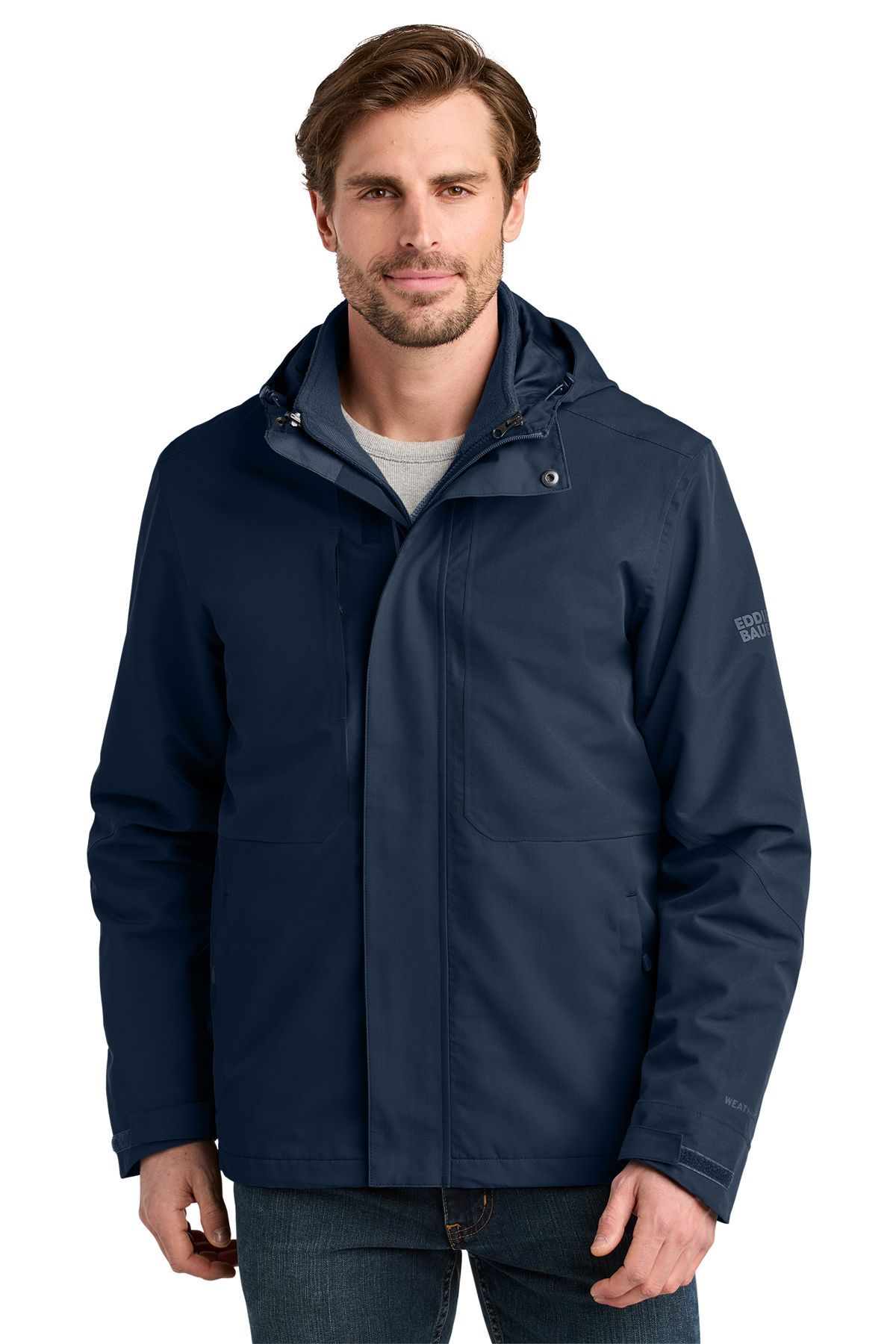 Man in dark gray and light gray winter jacket with hood, in a studio setting.
