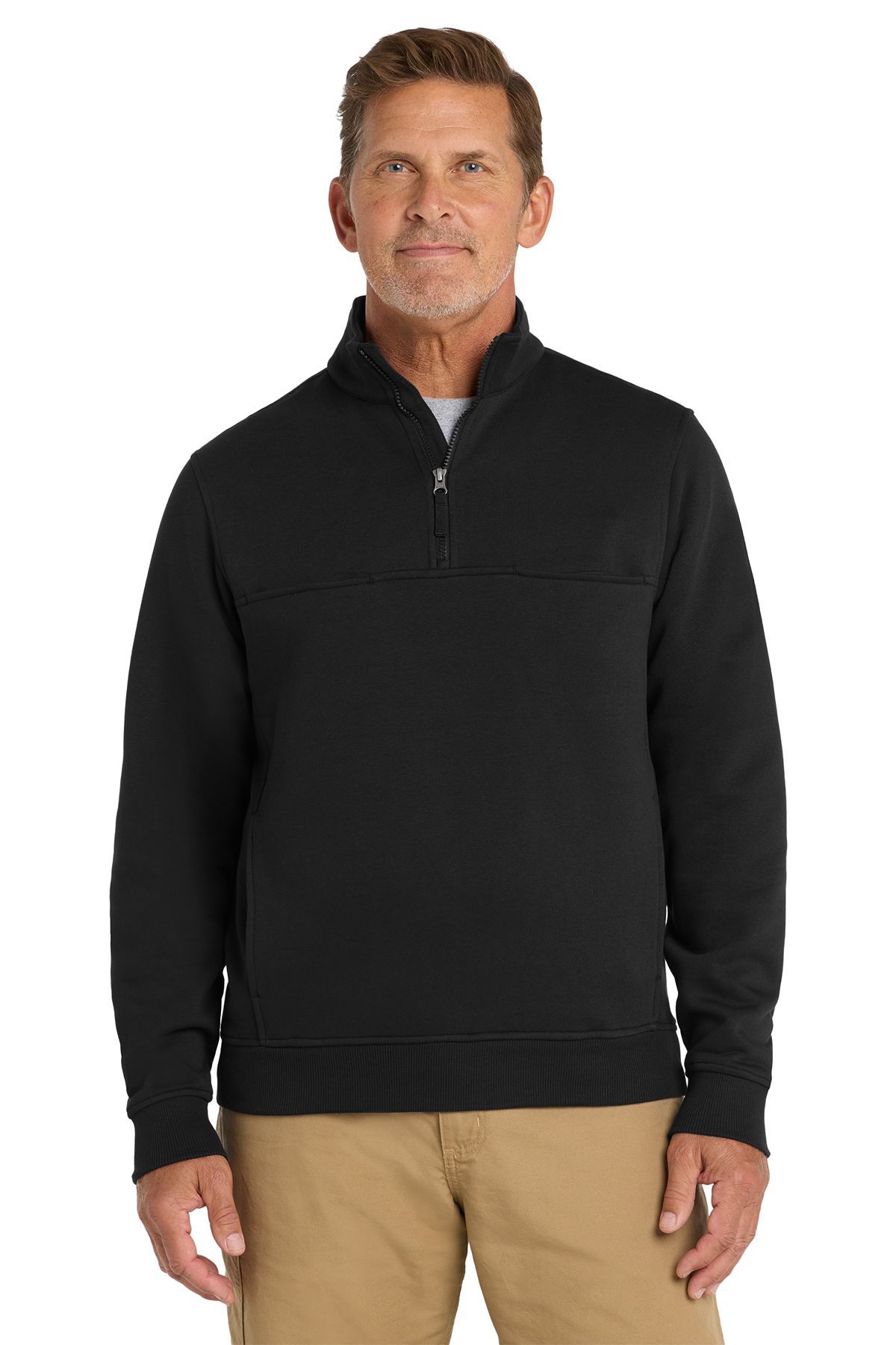 Man in navy blue zip-up sweater and khaki pants, standing against a white background.
