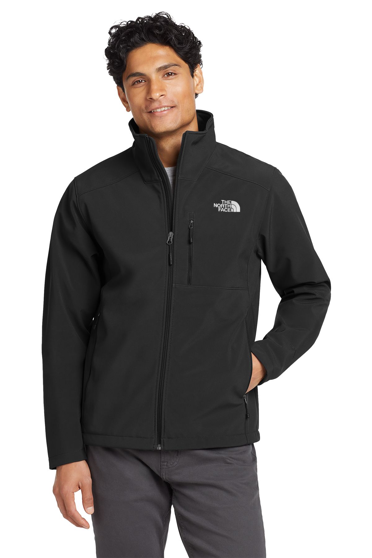 Man in black North Face jacket, smiling, standing outdoors.