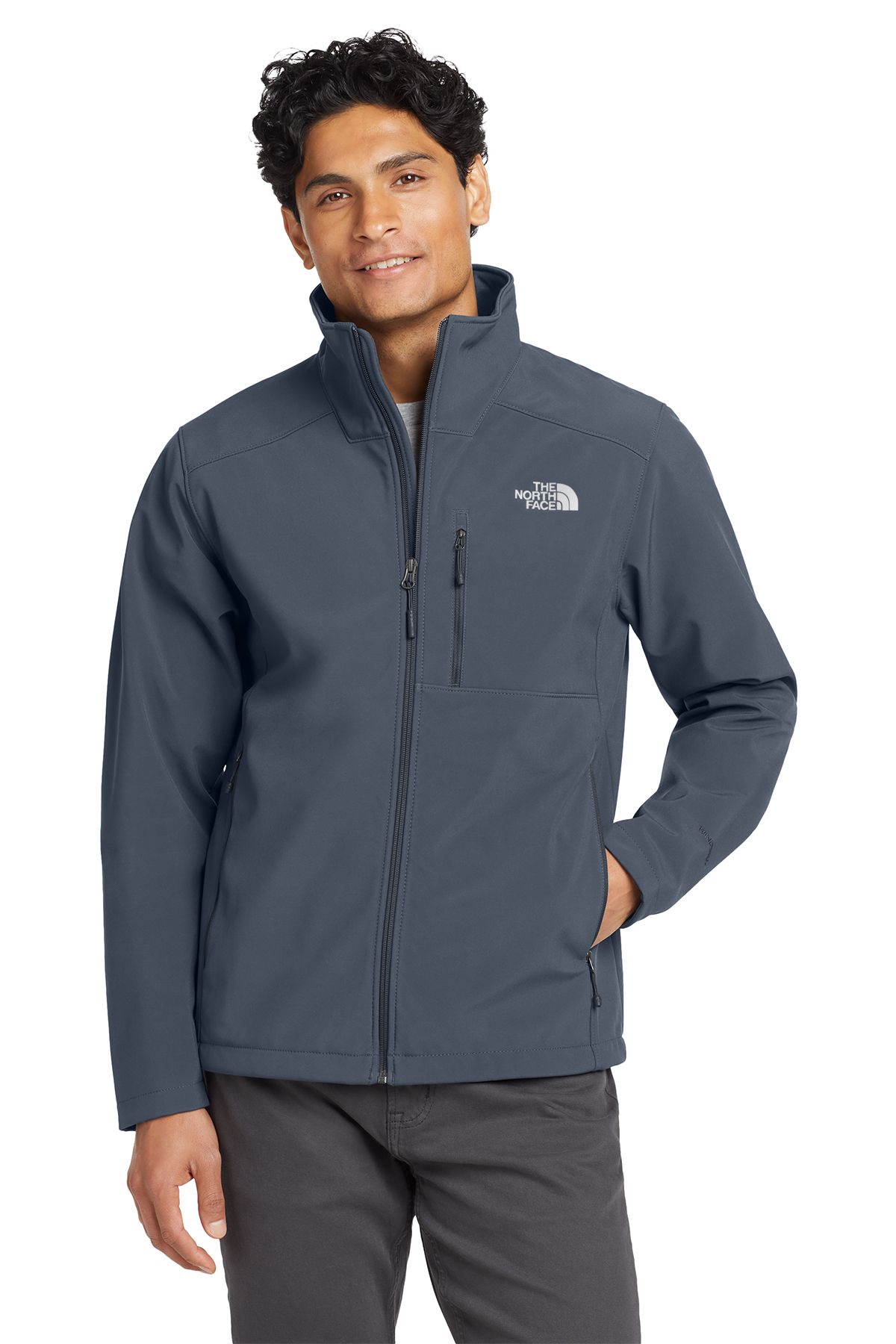 Man wearing a blue North Face jacket, smiling, standing in front of a white backdrop.