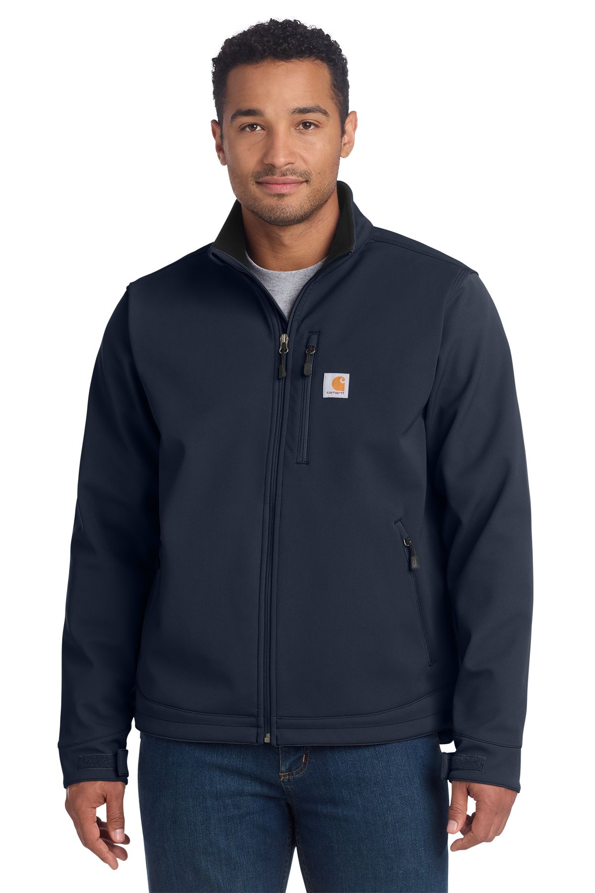 Man in navy Carhartt jacket, wearing a grey shirt, standing, with a neutral expression.
