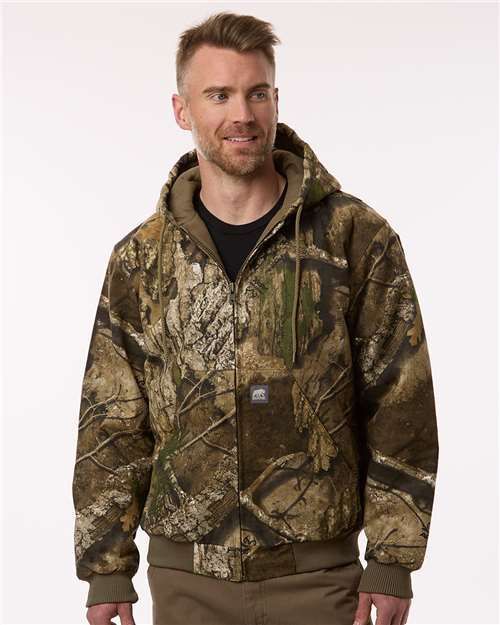 Man in camo jacket with hood smiles.