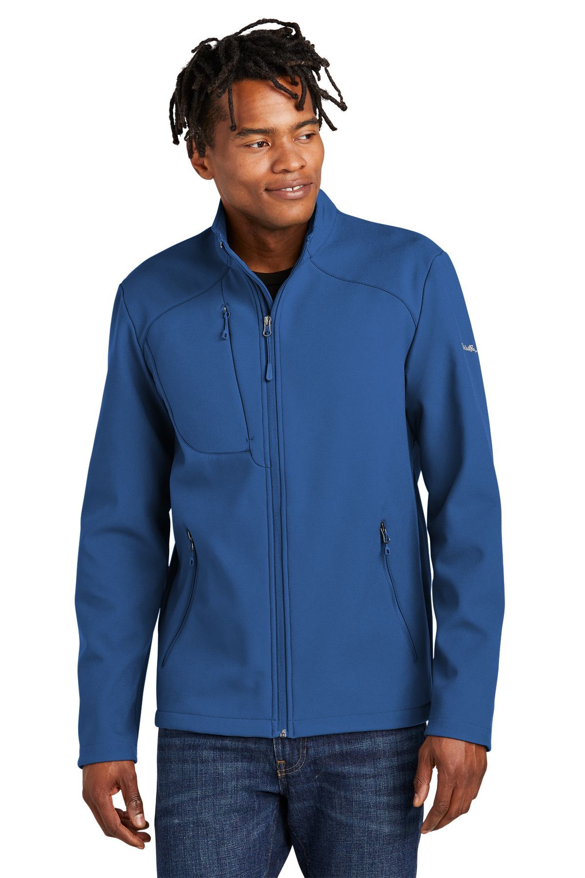 Man wearing a blue zip-up jacket, standing against a white background.