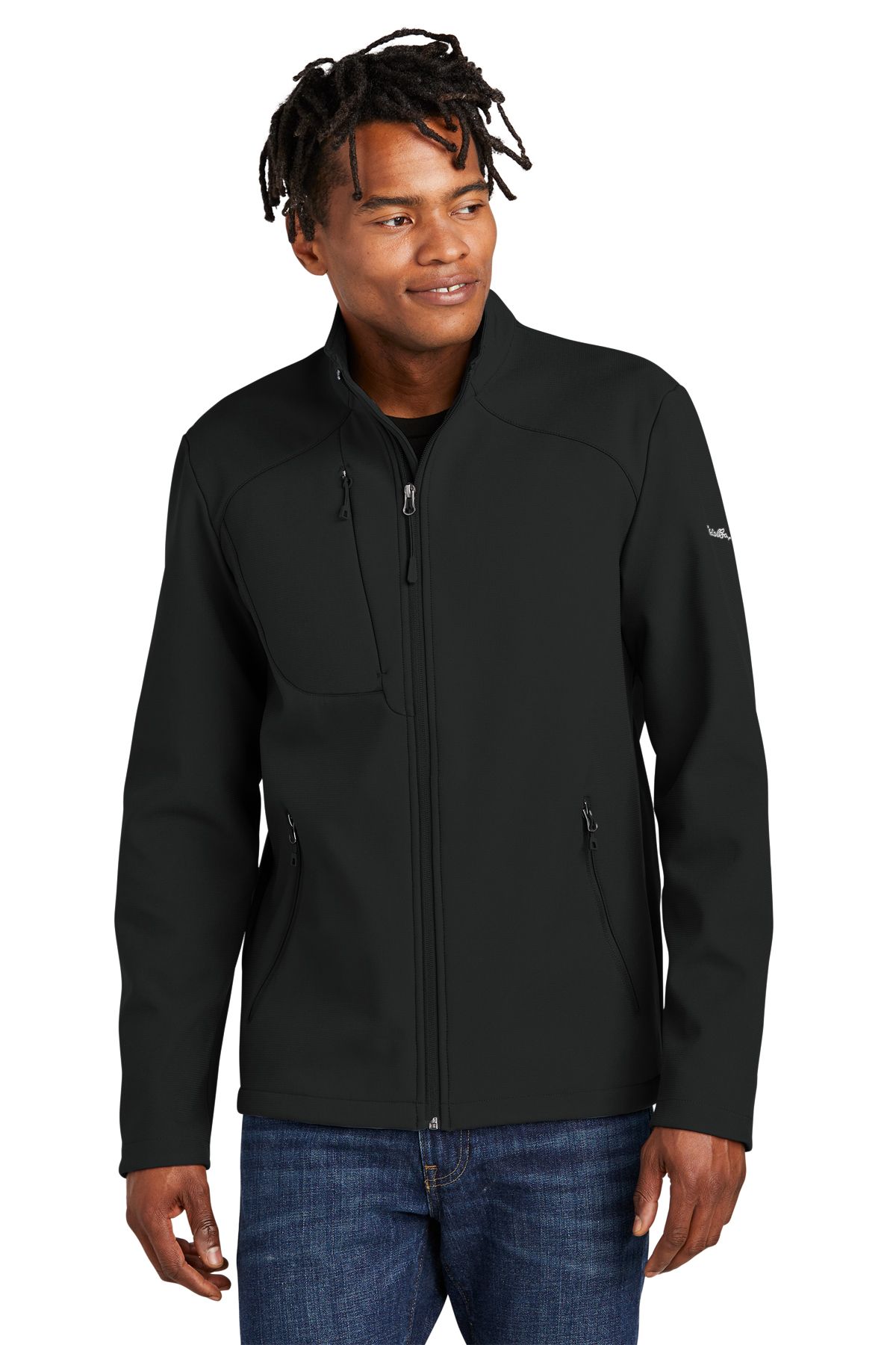 Man wearing a black jacket with front zipper, standing and smiling.