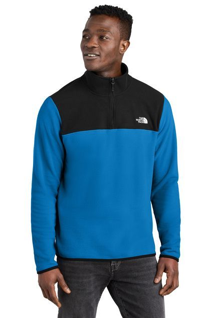 Man wearing a blue and black North Face fleece jacket, standing in front of a white background.