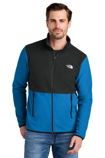 Man in a black and red North Face fleece jacket, standing in front of a white background.