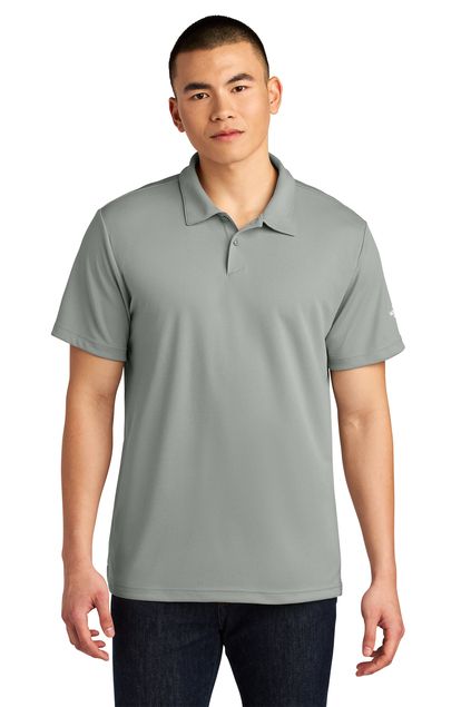 Man in blue polo shirt, smiling, posing for photo, neutral background.