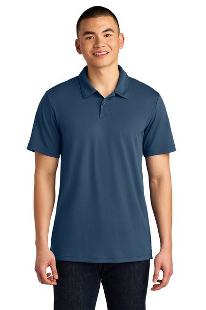 Man in blue polo shirt, smiling, posing for photo, neutral background.