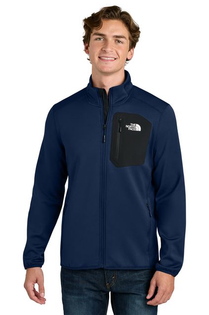 Man wearing a maroon North Face jacket with black chest pocket, smiling.