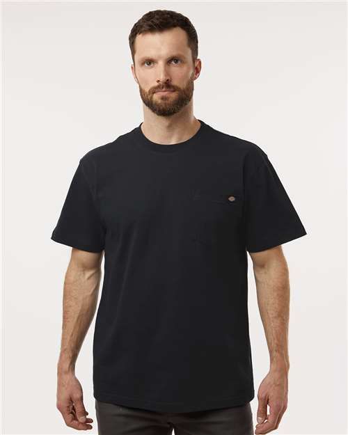 Man wearing a dark navy blue pocket t-shirt, standing and looking forward.