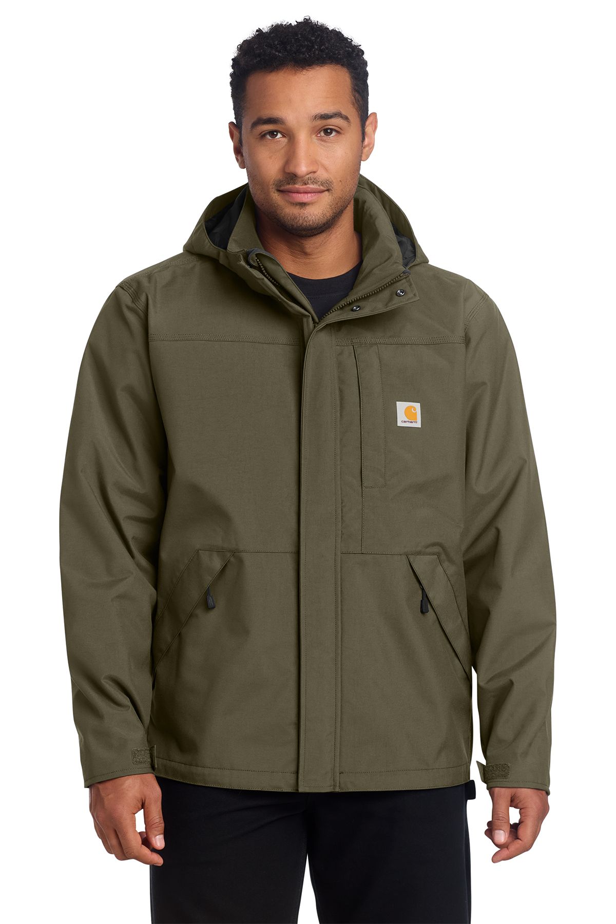 Man wearing an olive green Carhartt jacket with a hood, standing outdoors.