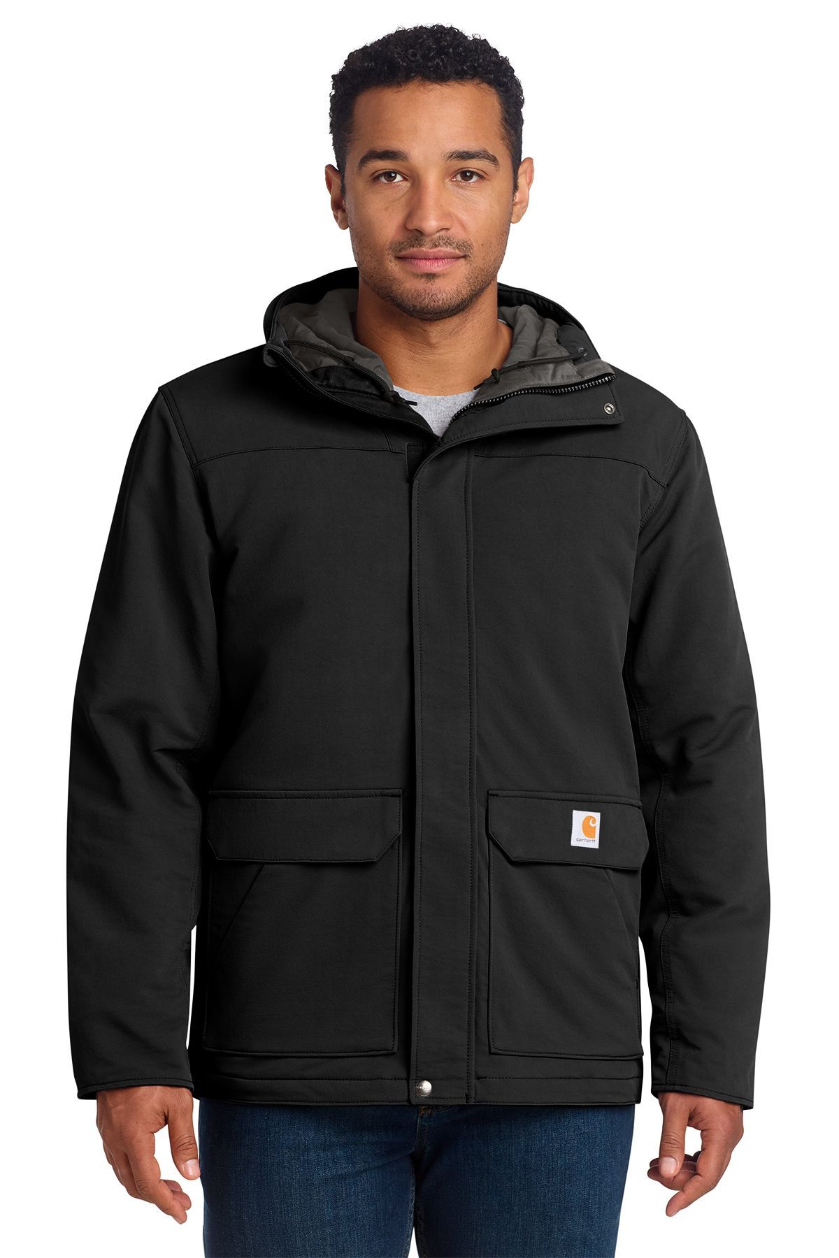 Man wearing a black Carhartt jacket with a hood, standing outdoors.