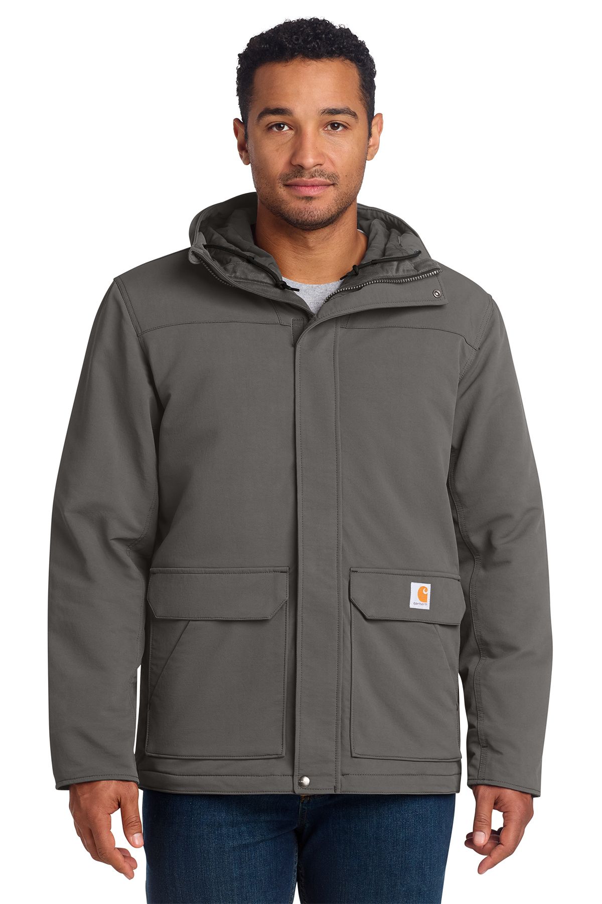 Man wearing a navy blue Carhartt jacket with a hood, standing outdoors.