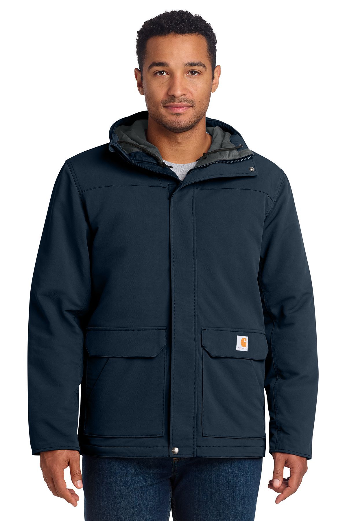 Man wearing a navy blue Carhartt jacket with a hood, standing outdoors.