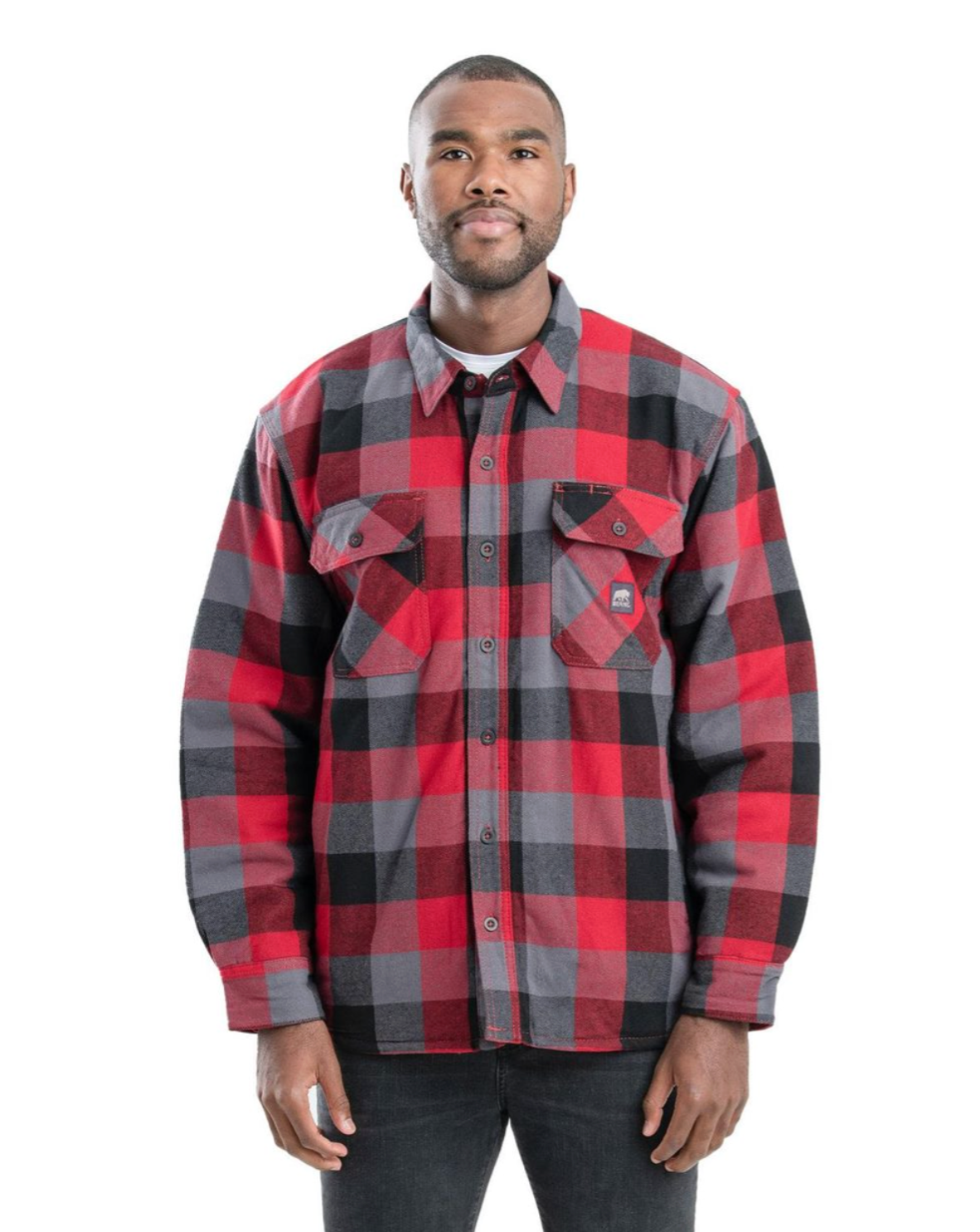Man in red, gray, and black plaid flannel shirt, buttoned up, over a white shirt.