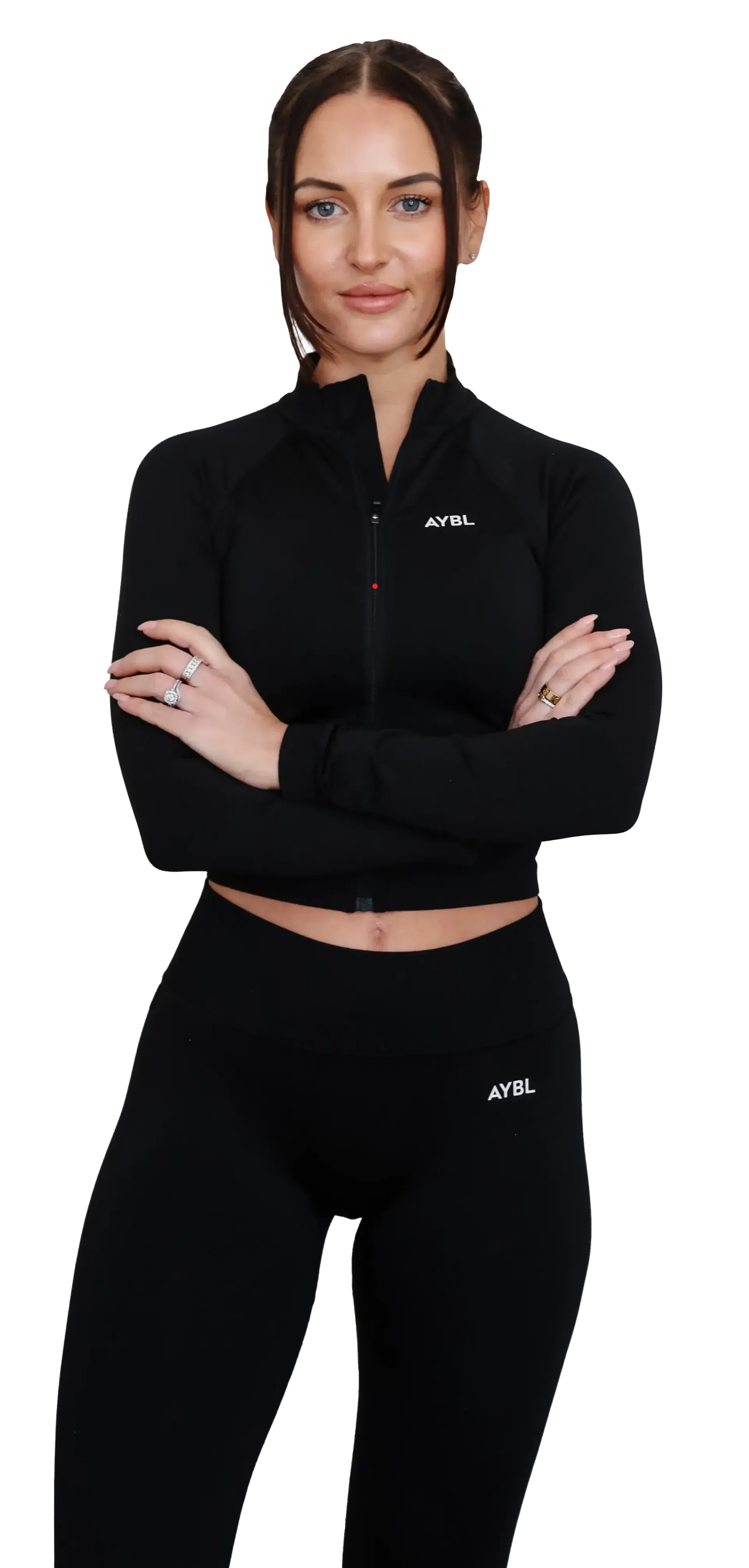 Woman in black athletic wear with arms crossed, smiling.