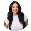 Smiling woman with long dark hair in a white shirt against a plain white background