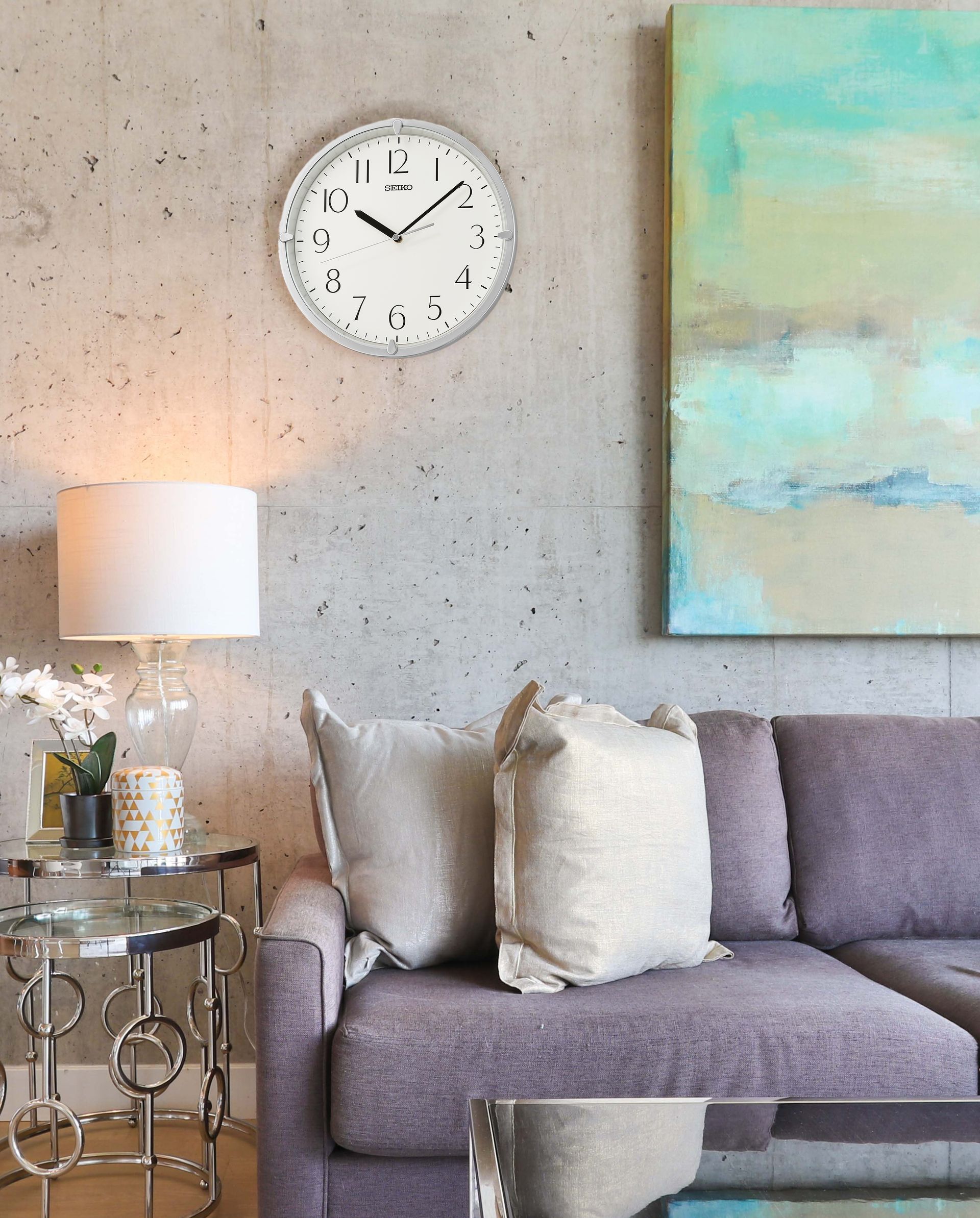 A living room with a couch and a clock on the wall