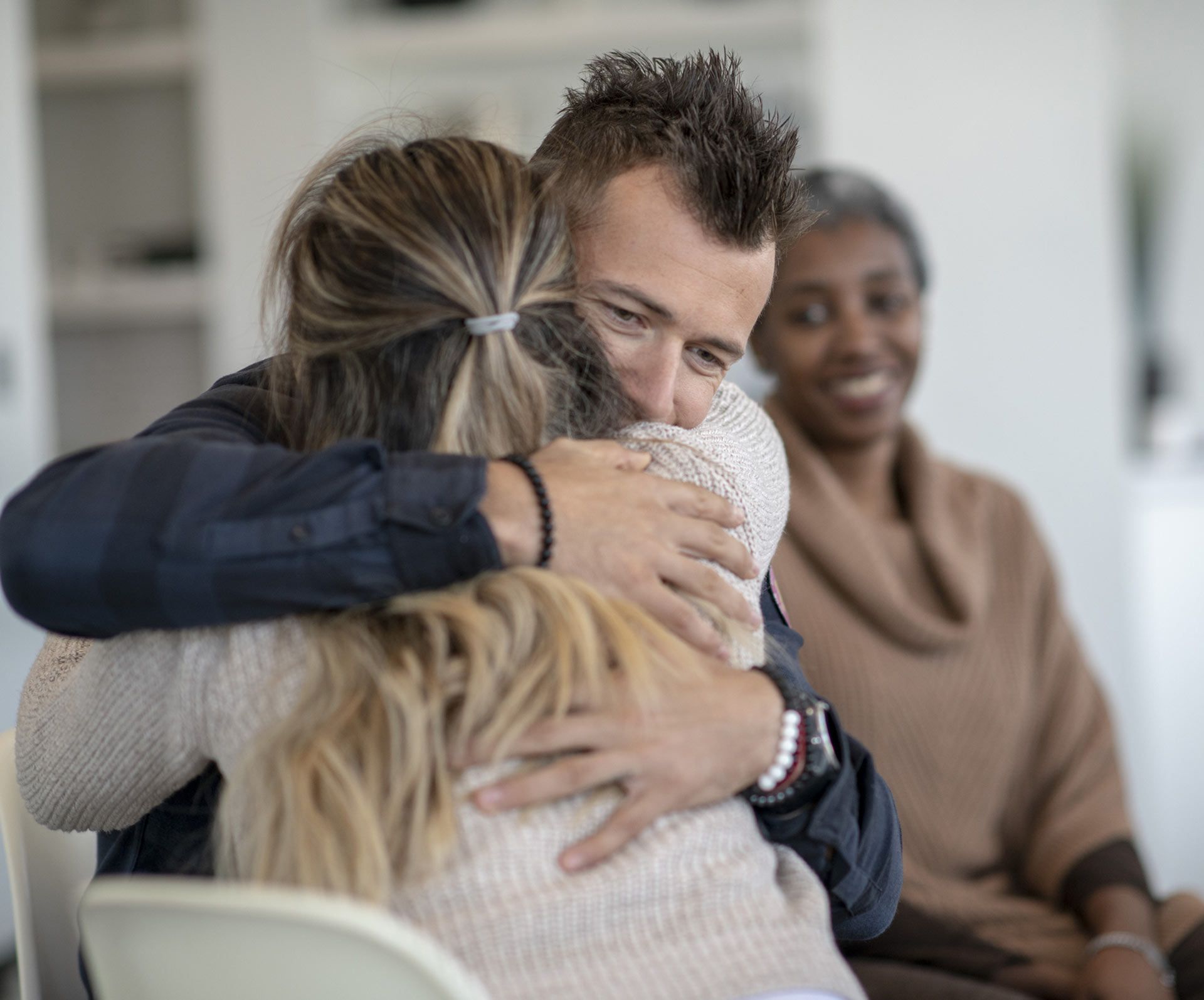 A man is hugging a woman while sitting in a chair