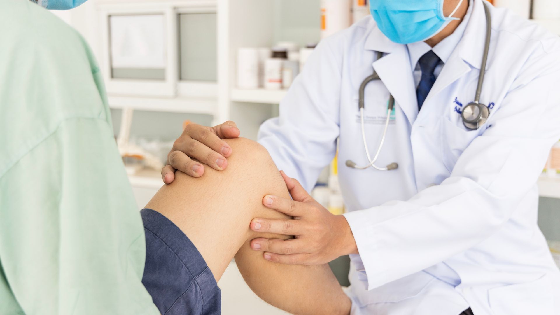 The orthopedic doctor checks the patient’s knee for injury or mobility limits. The orthopedic doctor checks the patient’s knee for injury or mobility limits.