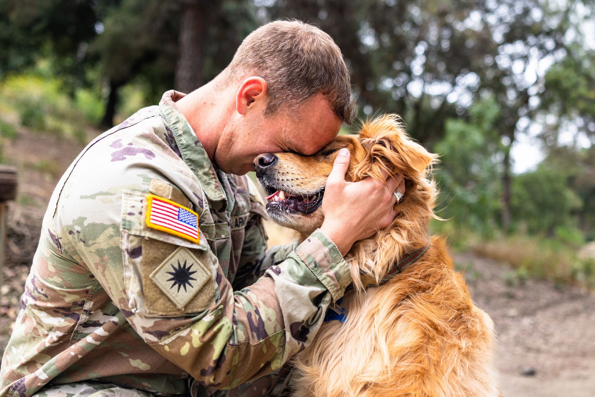 A man in a military uniform is petting a dog — DFW, TX — Texas Non-Surgical Orthopedic A man in a military uniform is petting a dog — DFW, TX — Texas Non-Surgical Orthopedic