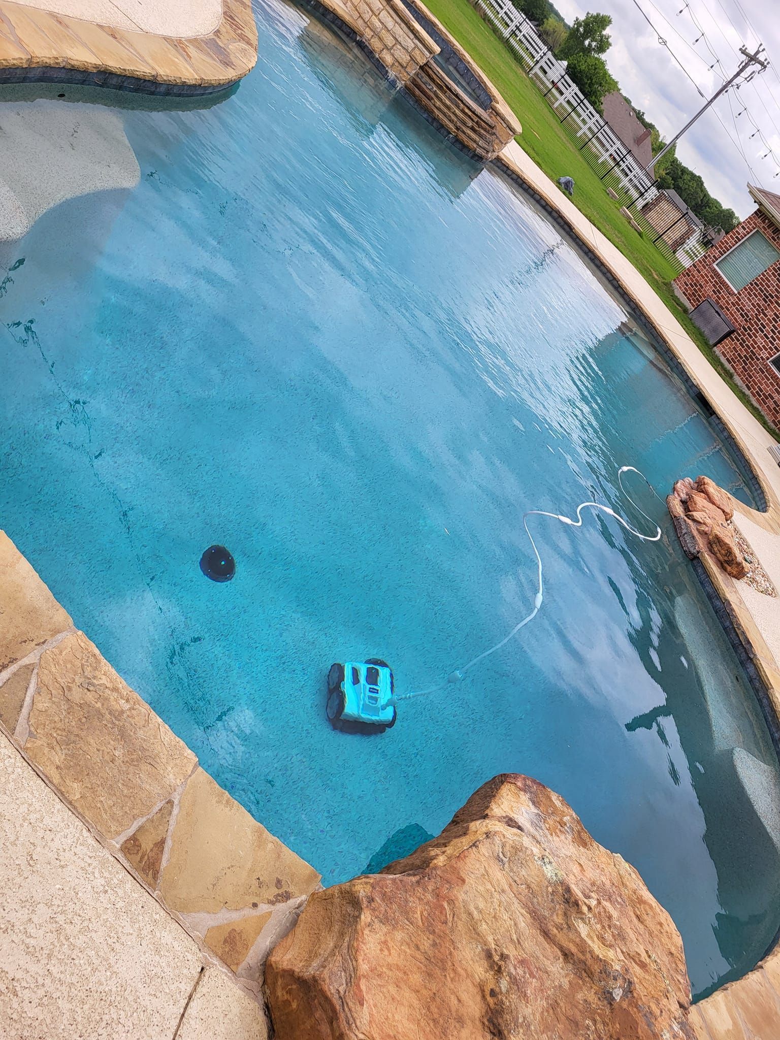 Blue swimming pool with a small floating object, viewed from above at an angle