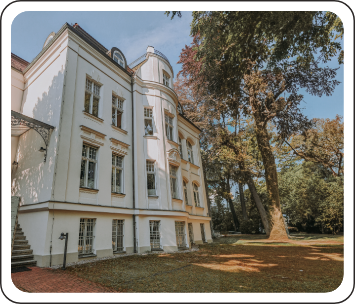Ein großes weißes Gebäude mit Bäumen davor