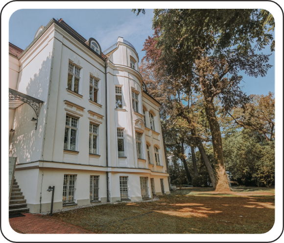 Ein großes weißes Gebäude mit Bäumen davor