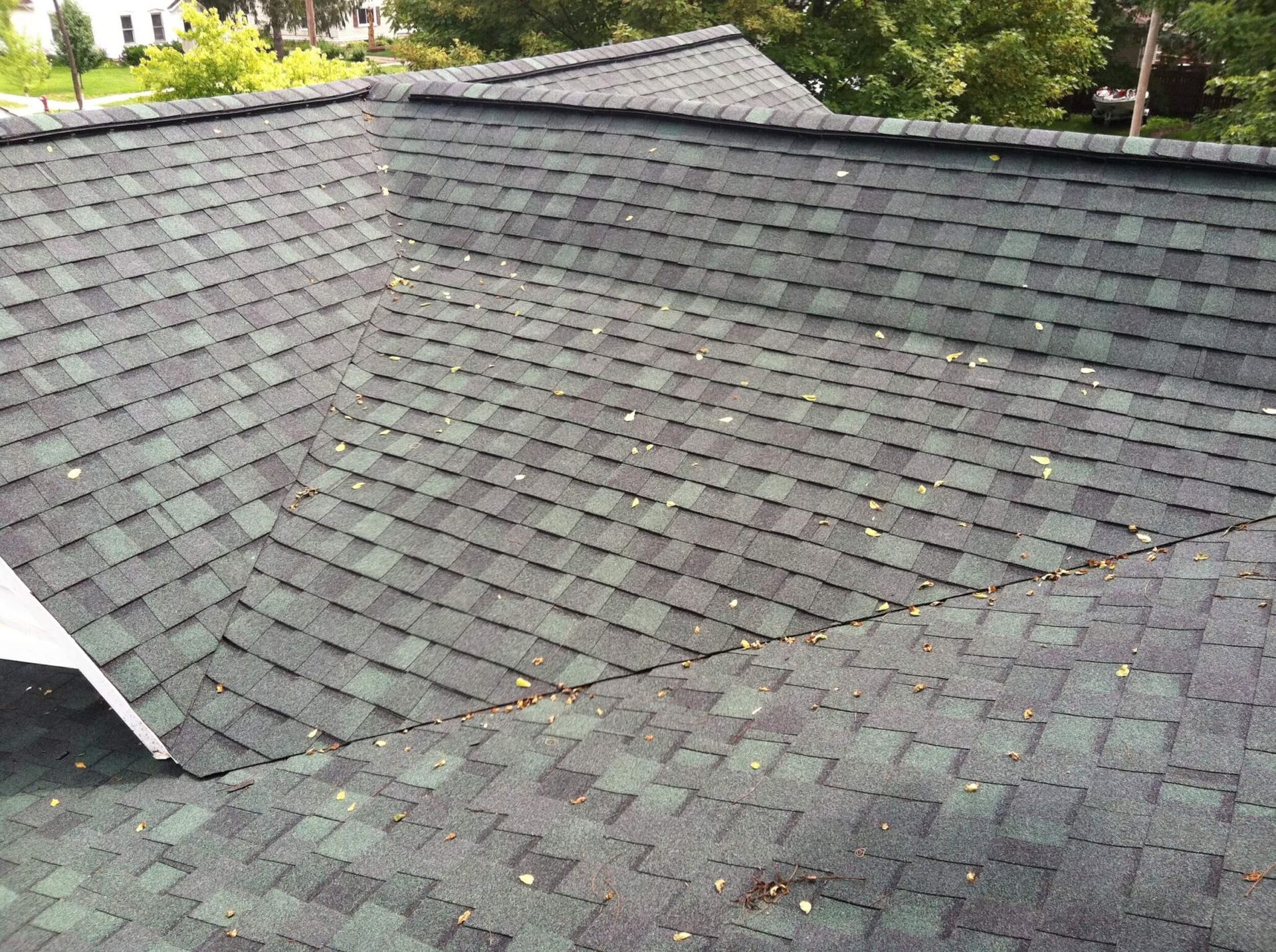 Dark gray shingled roof with a few trees visible above the ridge