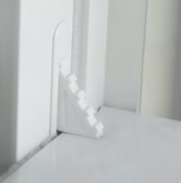 White doorframe corner with a small leaning plastic piece on the floor