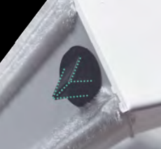Black speaker with turquoise LED dots mounted in a gray corner