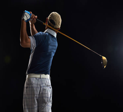 A man is swinging a golf club on a black background.