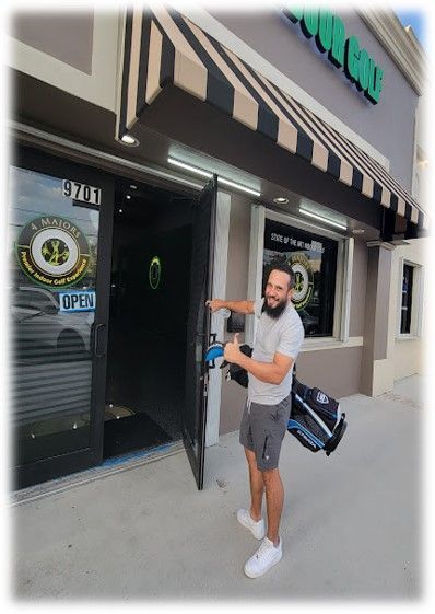 A man is standing in front of a store that is open