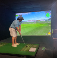 A man is playing a video game of golf