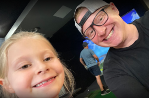 A man and a little girl are smiling for the camera