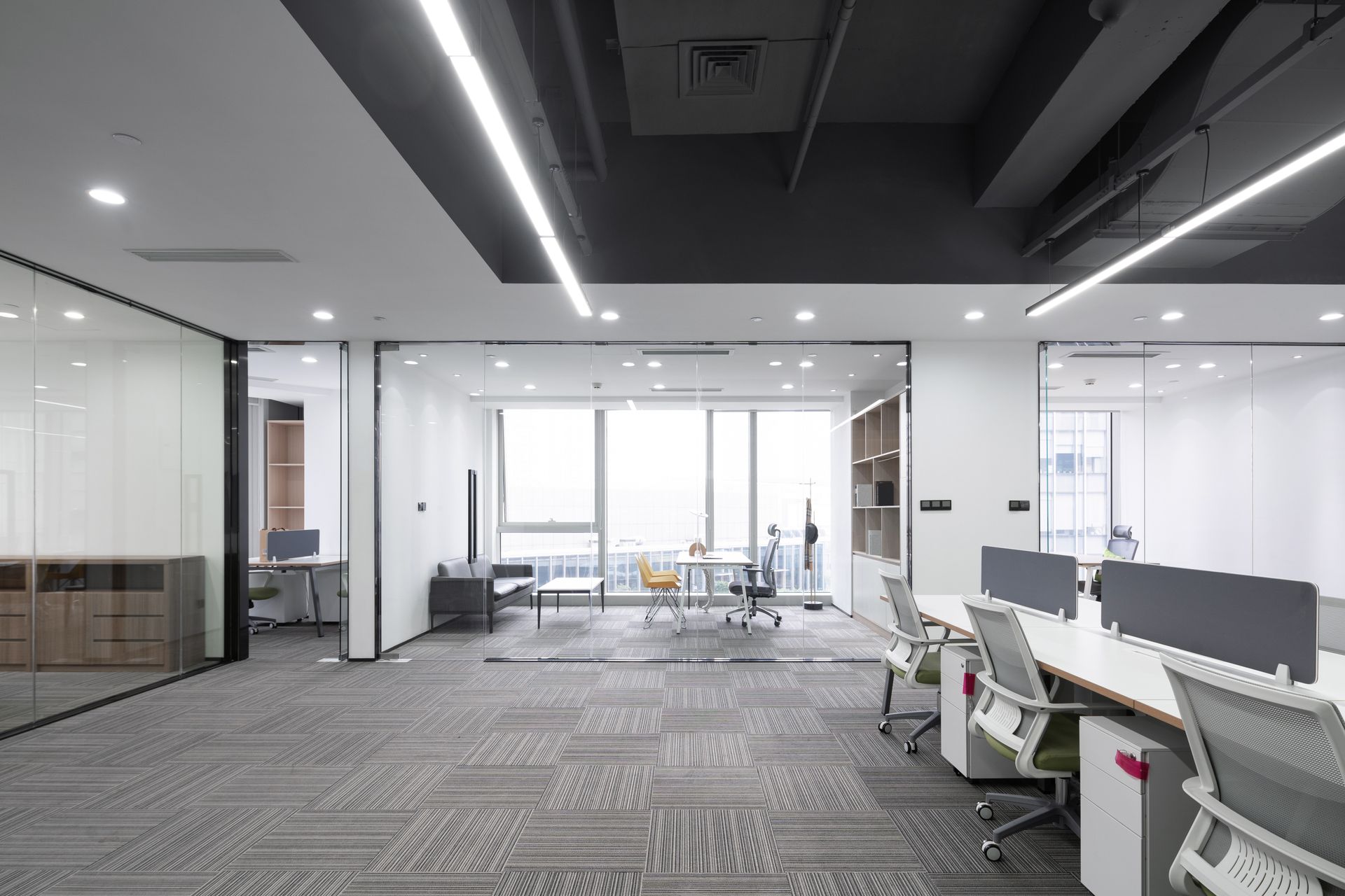 A large empty office with a lot of desks and chairs.