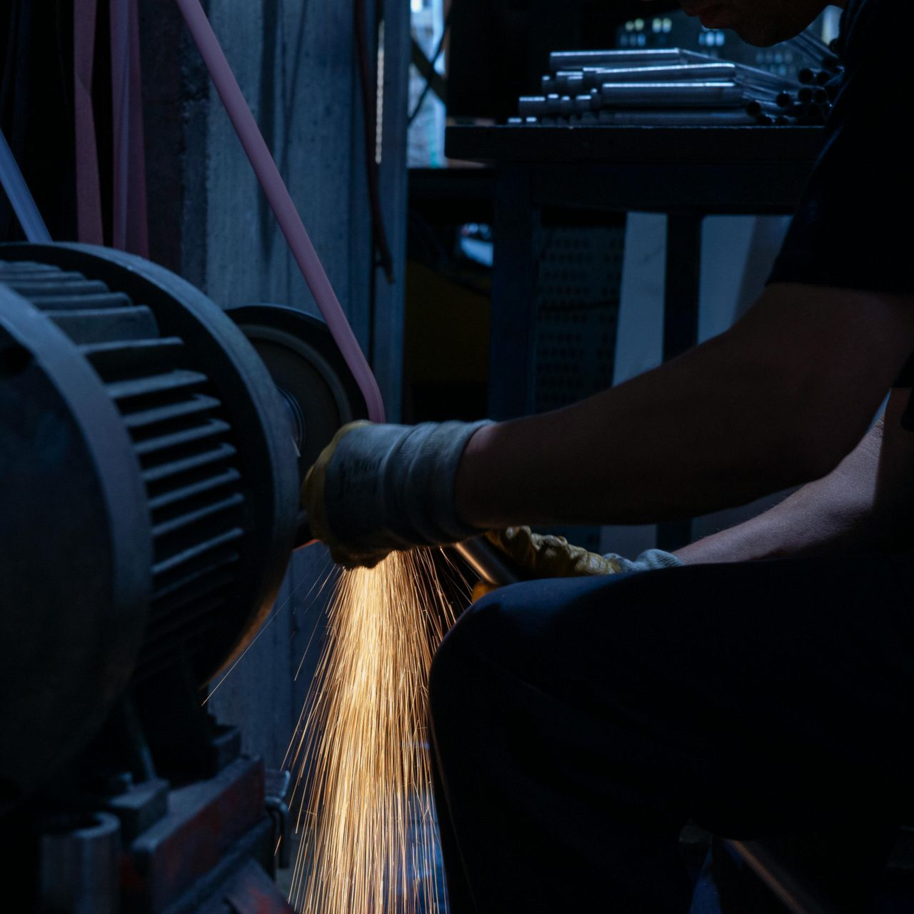 A person grinding metal, creating sparks.