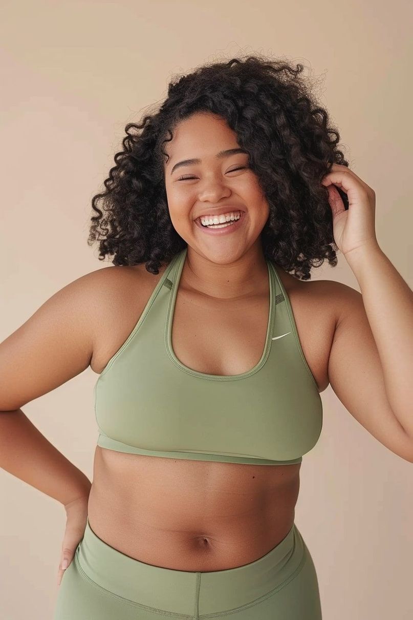 Woman laughing in green activewear representing community and confidence in Her Form's program.
