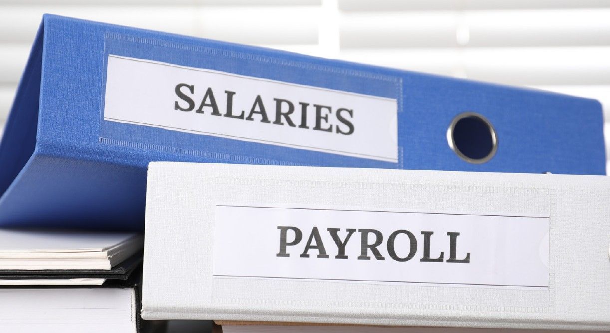 Salary and payroll binders representing employee compensation records.