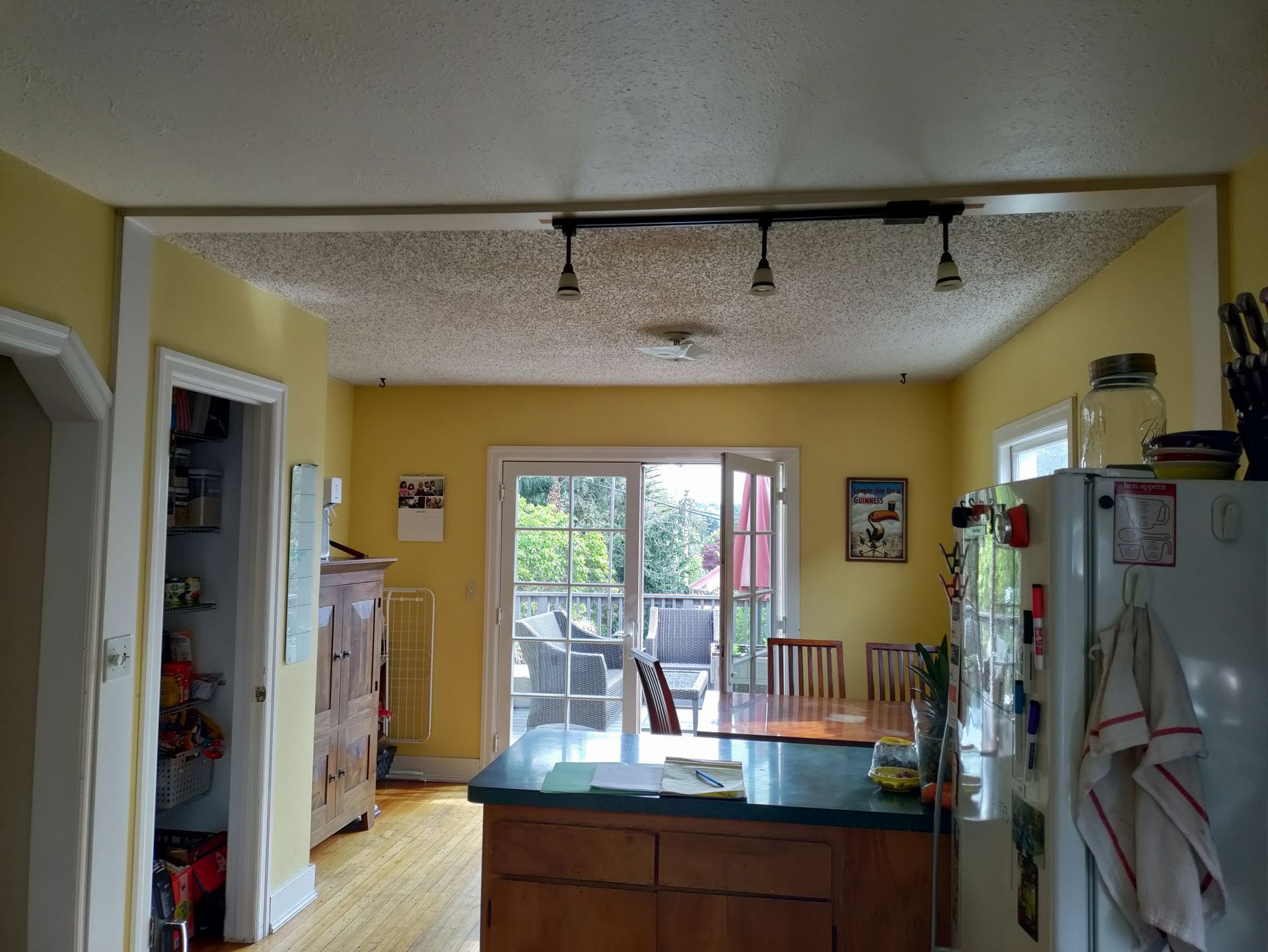Kitchen with yellow walls, dark wood cabinets, and glass doors opening to a sunny patio.