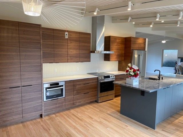 Modern kitchen with wood cabinets, stainless appliances, and a dark island counter
