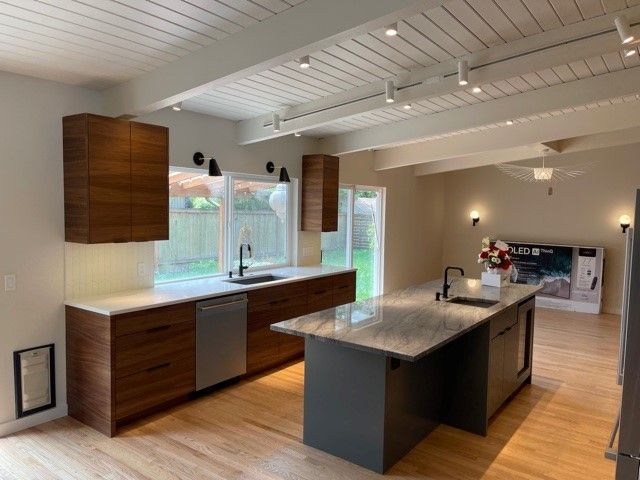 Modern kitchen with wood cabinets, large island, stainless sink, and bright windows